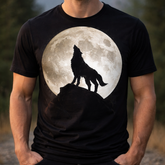 Person wearing a black t-shirt with a graphic of a wolf howling at a moon on a natural background